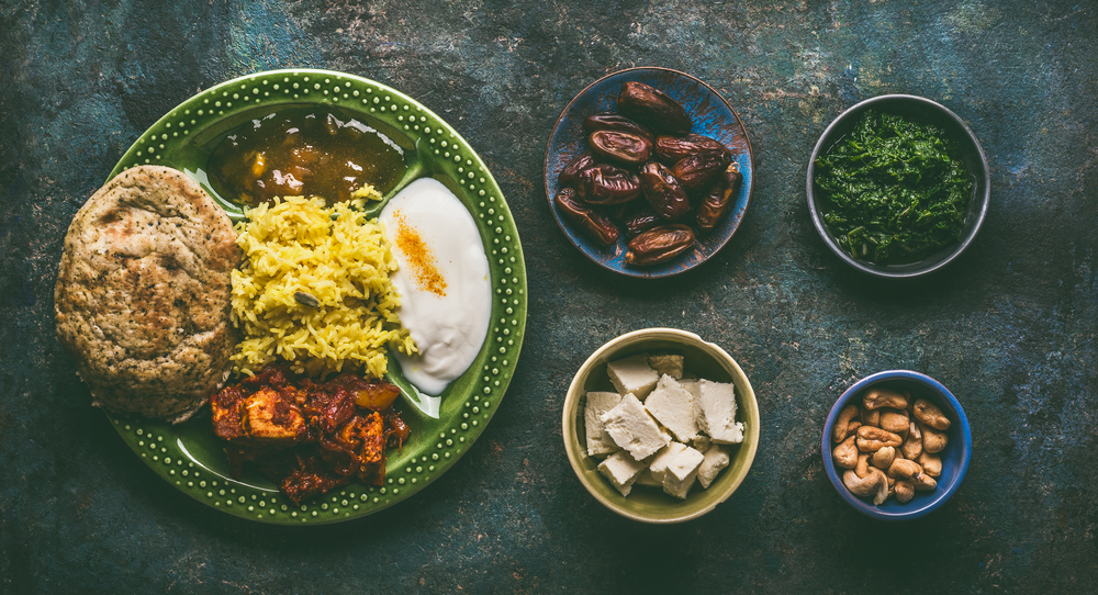 Various Indian foods in bowls on dark rustic background, top view