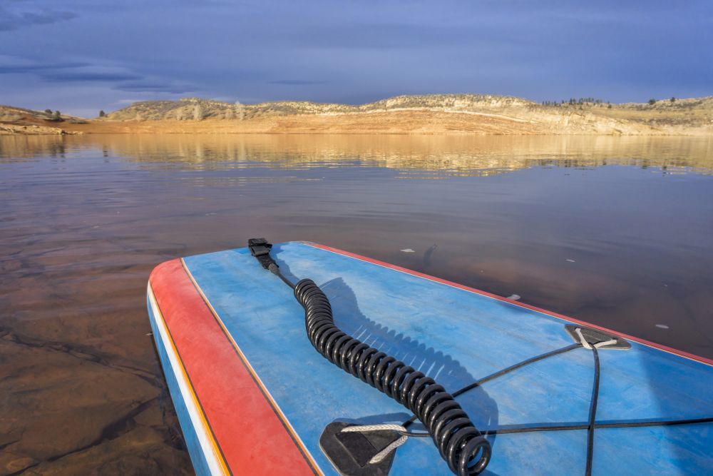stern of a tand up paddleboardwith safety leash  on a calm lake - Horsetooth Reservoir near Fort Collins, Colorado in winter scenery