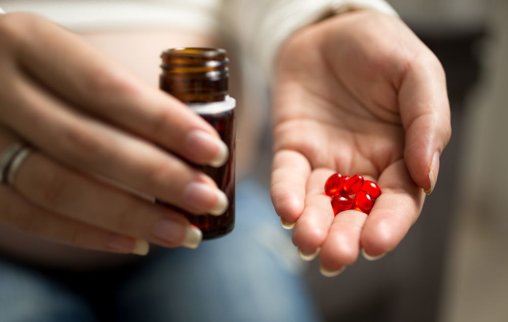 Closeup image of woman holding pills on hand