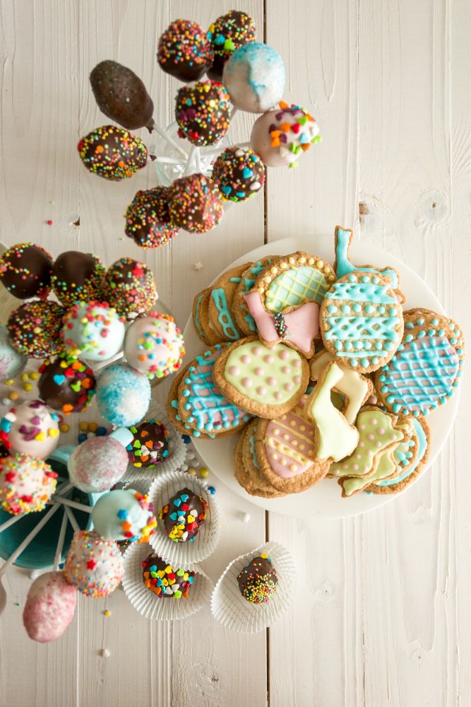 Top view photo of colorful cake pops and Easter cookies