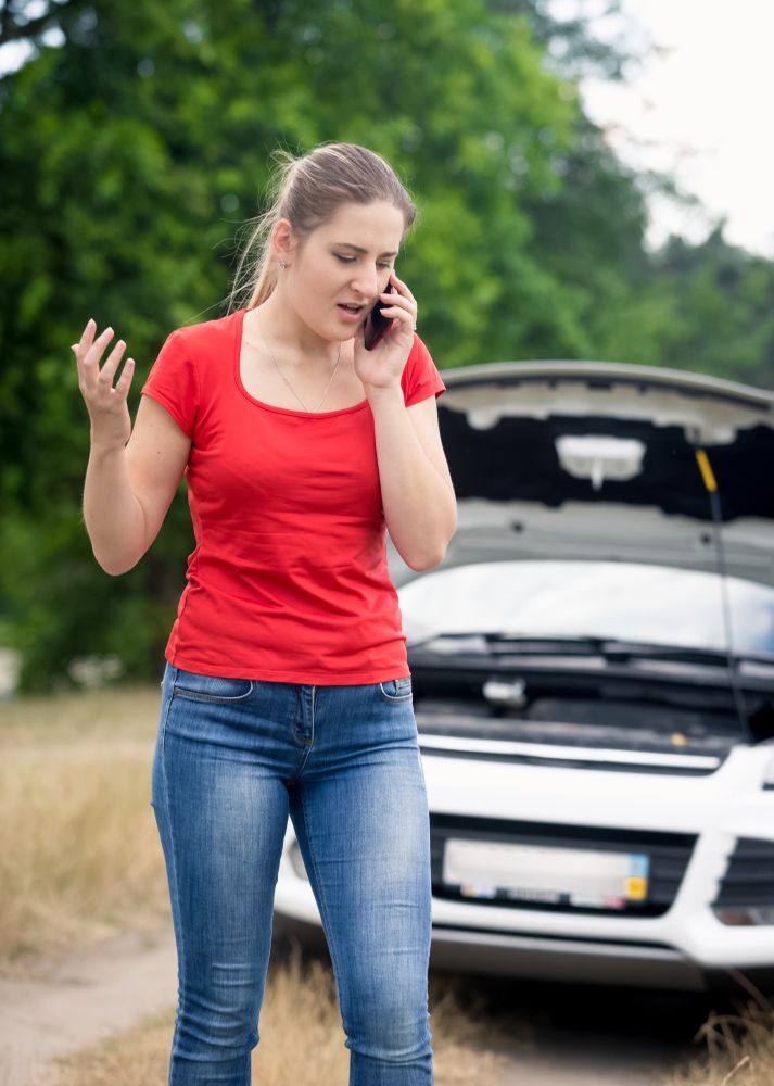 Woman shouting in mobile phone because of the broken car on rural road