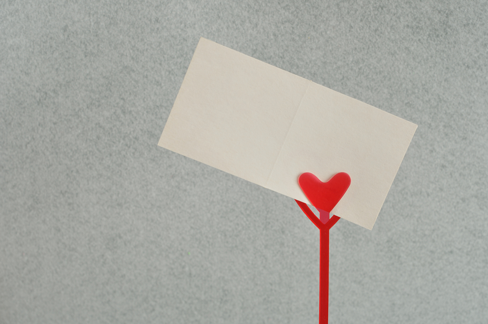 Valentines day. A note holder with a red heart with a note isolated against a white background