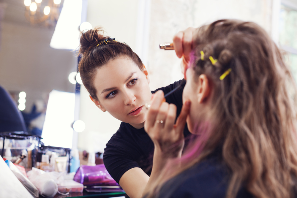 Make-up artist applying mascara on model&rsquo;s eyelashes, selective focus on make up artist