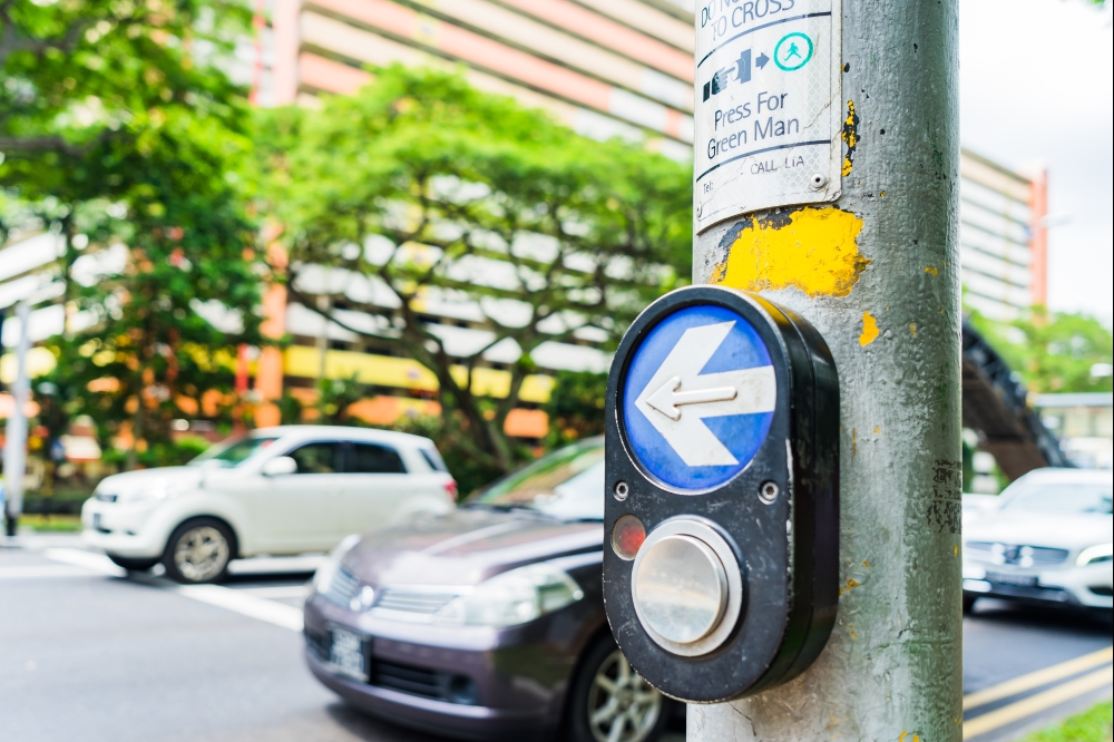 Button for traffic light and Cars in background. Traffic lights at the crossroads. Button of the mechanism lights traffic lights on the street. System control traffic light intersection close.. Button for traffic light and Cars in background.