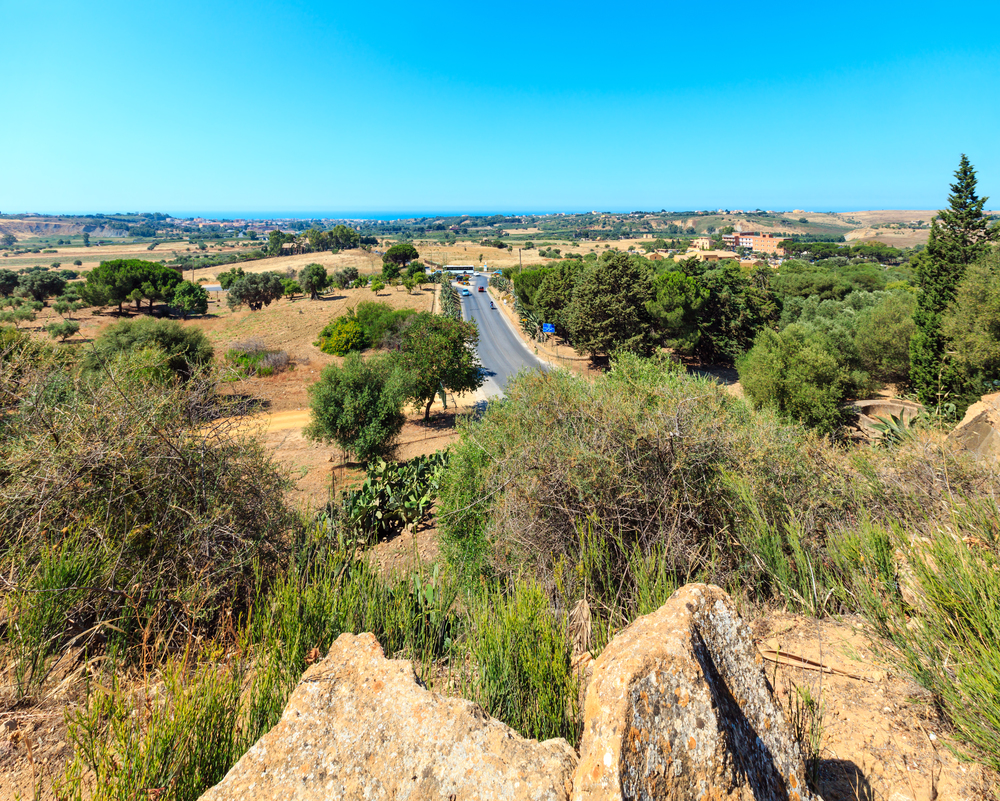View to road, gardens and sea from Valley of Temples, Agrigento, Sicily, Italy.