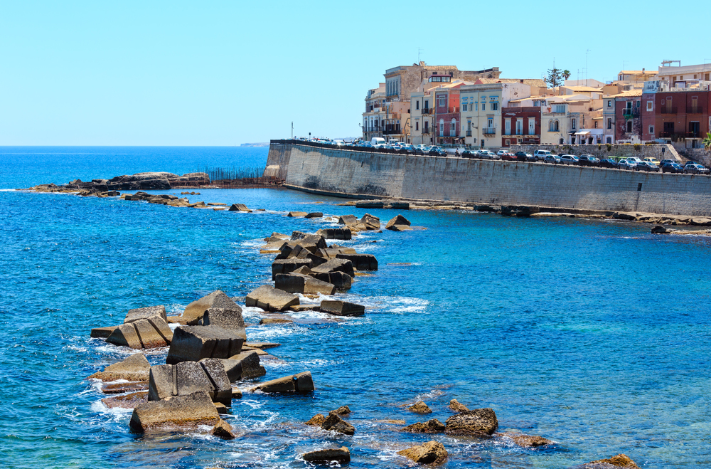 Coast of Ortigia island at city of Syracuse, Sicily, Italy. Beautiful travel photo of Sicily. People unrecognizable.