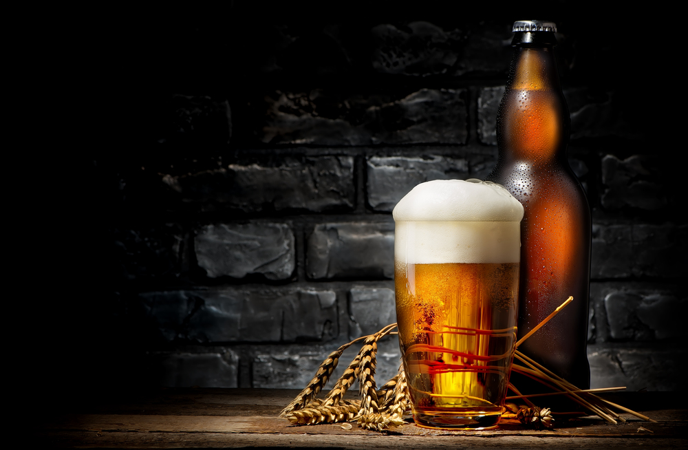 Beer in glass and bottle on wooden background. Beer in glass and bottle