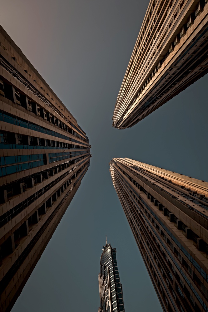 Perspective View on a Beautiful High Buildings on Overcast Sky Background. Futuristic Towers. Modern Architecture of Dubai. United Arab Emirates.. Dubai Towers Perspective View