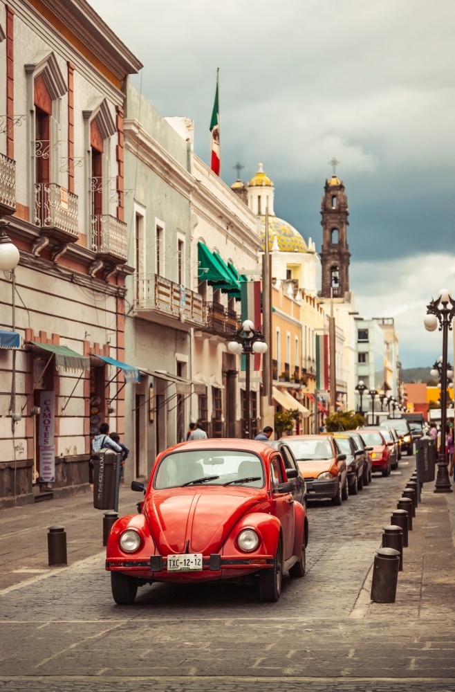 MEXICO - jule 14: beautiful view on a Mexican town with red Volkswagen Beetle vintage classic car in the foreground and a church in the background, Jule 14, 2012 Mexico