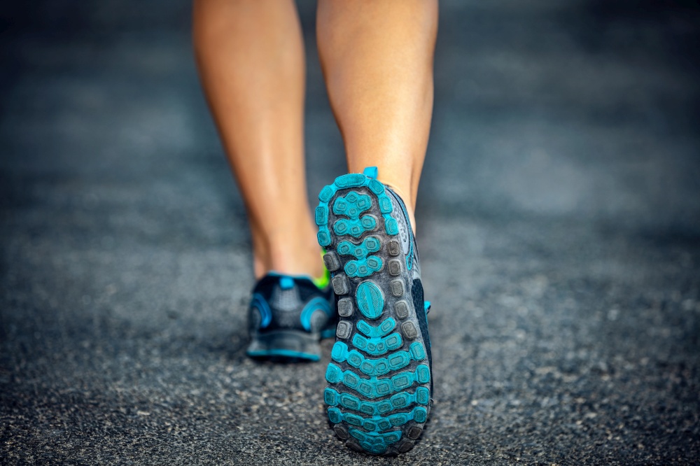 Active lifestyle, sporty female on a jog outdoor workout, closeup photo of the rear view of woman&rsquo;s legs, female wears sneakers, a healthy lifestyle, weight loss concept
