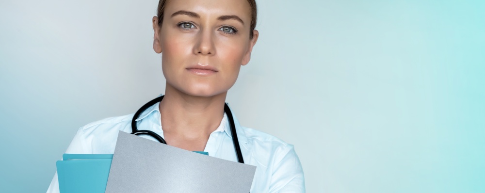 Portrait of a woman doctor holding medical records, isolated on blue background, Dr. at work, intern in the hospital, healthcare industry, panoramic photo with copy space