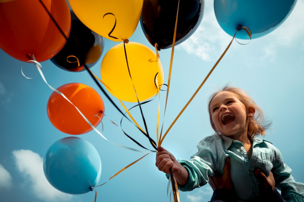 Happy birthday boy with colorful balloons over blue sky background, sincere emotions of a pretty child enjoying life
