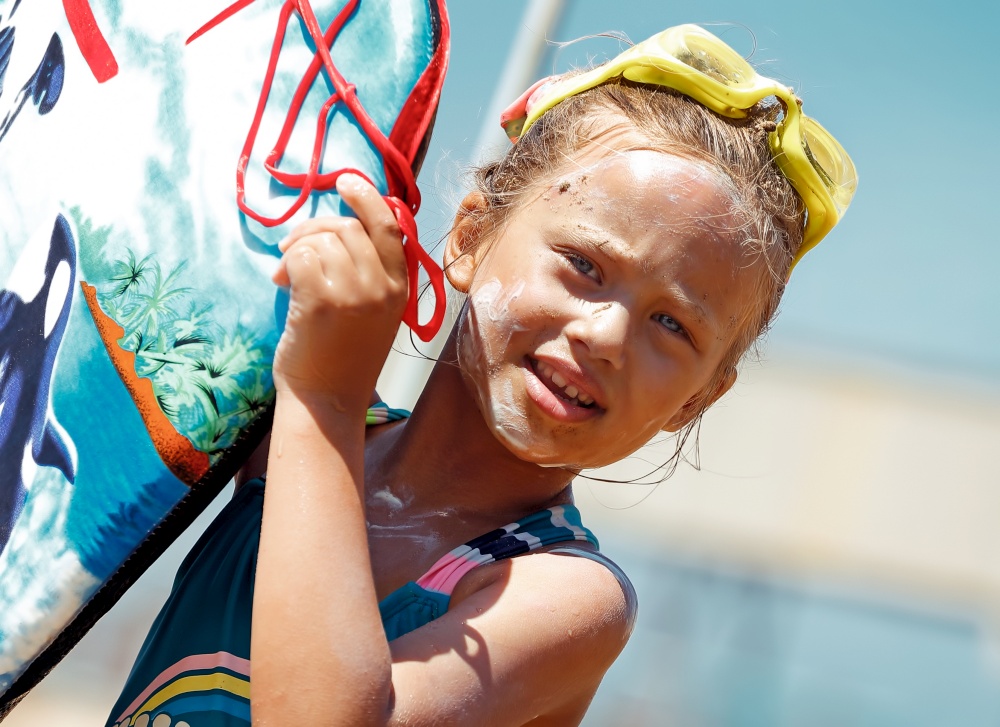 Portrait of a Nice Little Girl Wearing Goggles with Sunscreen on Face Holding Body Board. Spending Summer Vacation on the Sea. Happy Leisure Time on the Beach Resort. Healthy Sportive Childhood.