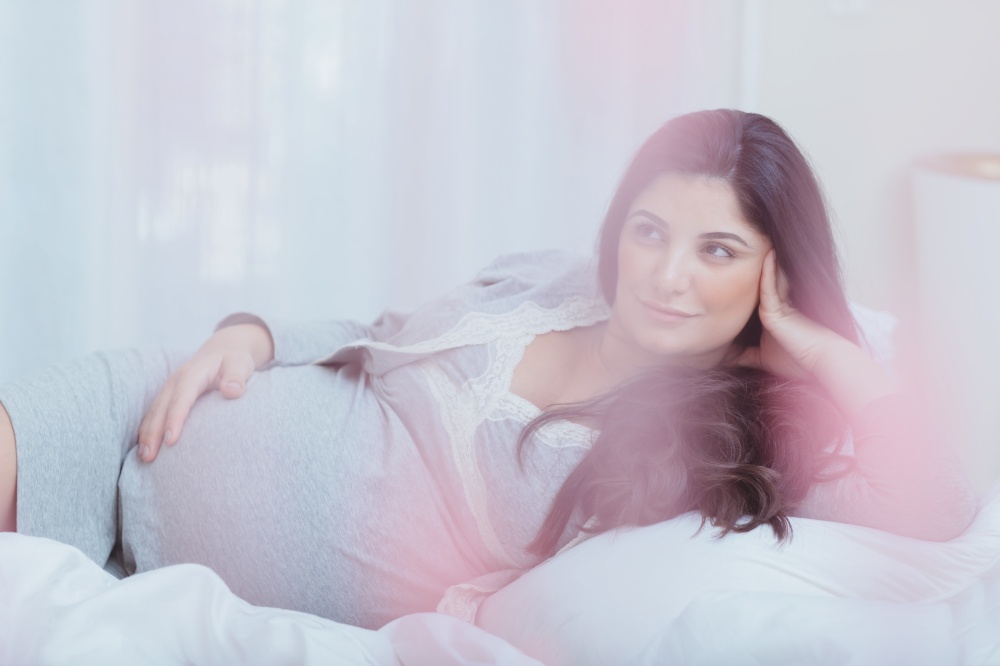 Nice Pregnant Woman with Pleasure Spending Time at Home. Resting on the Bed. Happy Healthy Parenthood. Family Love Concept.. Beautiful Pregnant Woman at Home