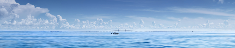 Man fishing from boat with Sunshine Skyway Bridge,Florida in Background
