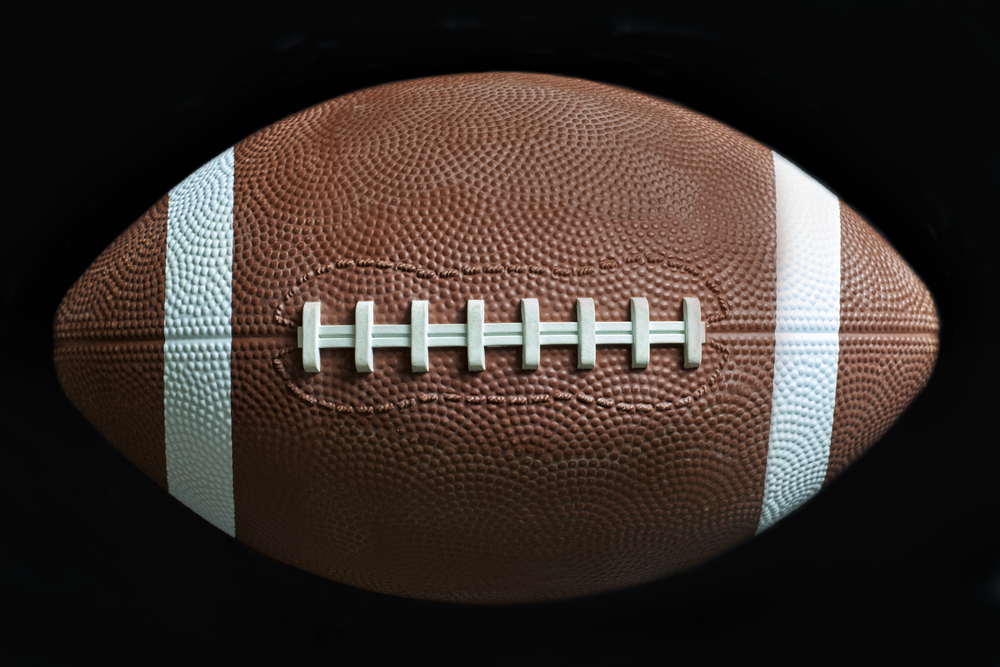 Close up of a American football on black background