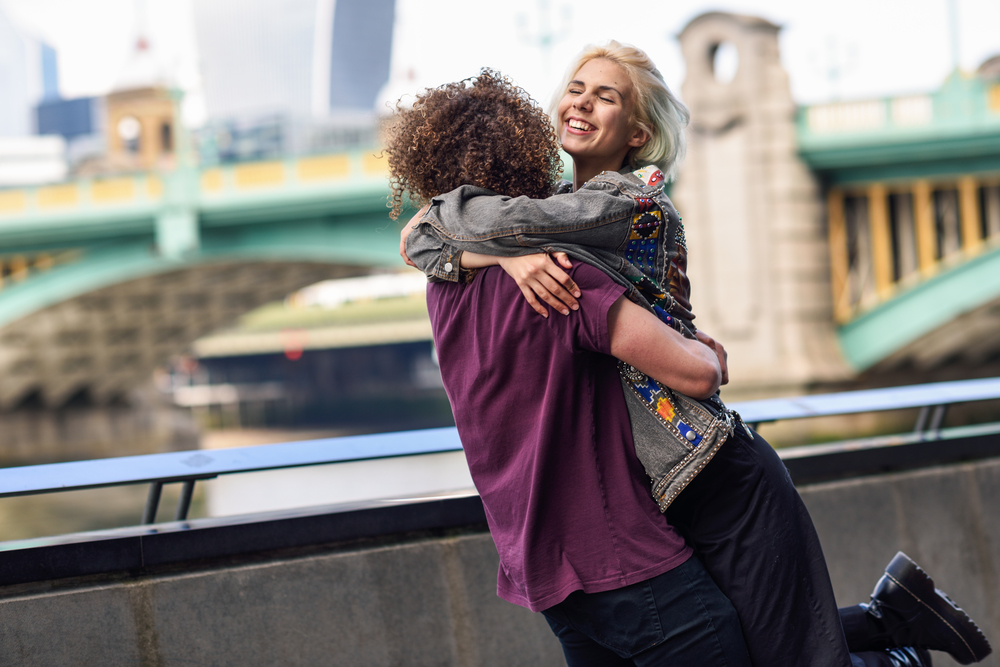 Happy couple hugging near the Southwark bridge over River Thames, London. UK. Happy couple hugging near the Southwark bridge over River Thames, London