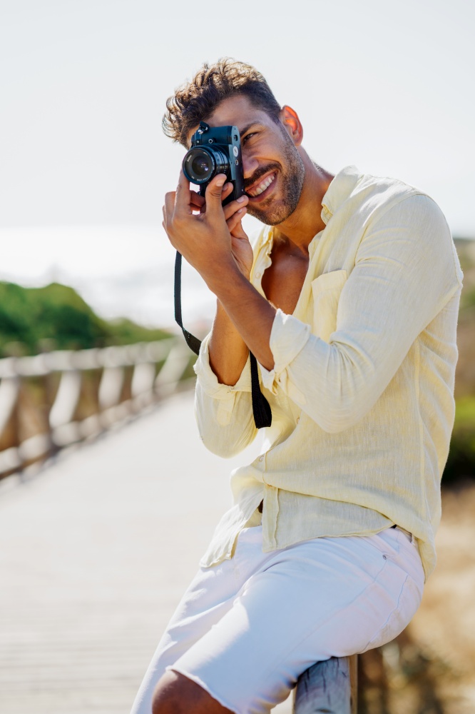 Handsome man photographing in a coastal area with an SLR camera. Handsome man photographing in a coastal area.