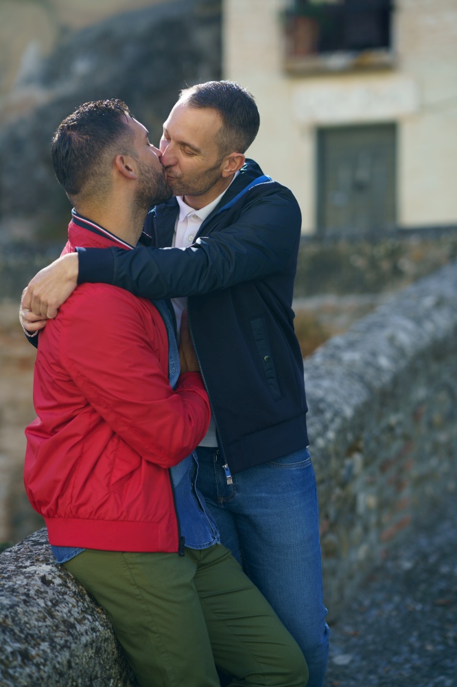 Gay couple kissing a beautiful place near the river. Homosexual relationship concept.. Gay couple kissing a beautiful place near the river.