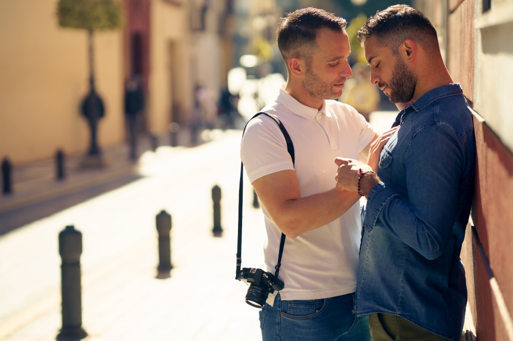 Gay couple tourists in a romantic moment on the street. Homosexual relationship concept.. Gay couple in a romantic moment outdoors