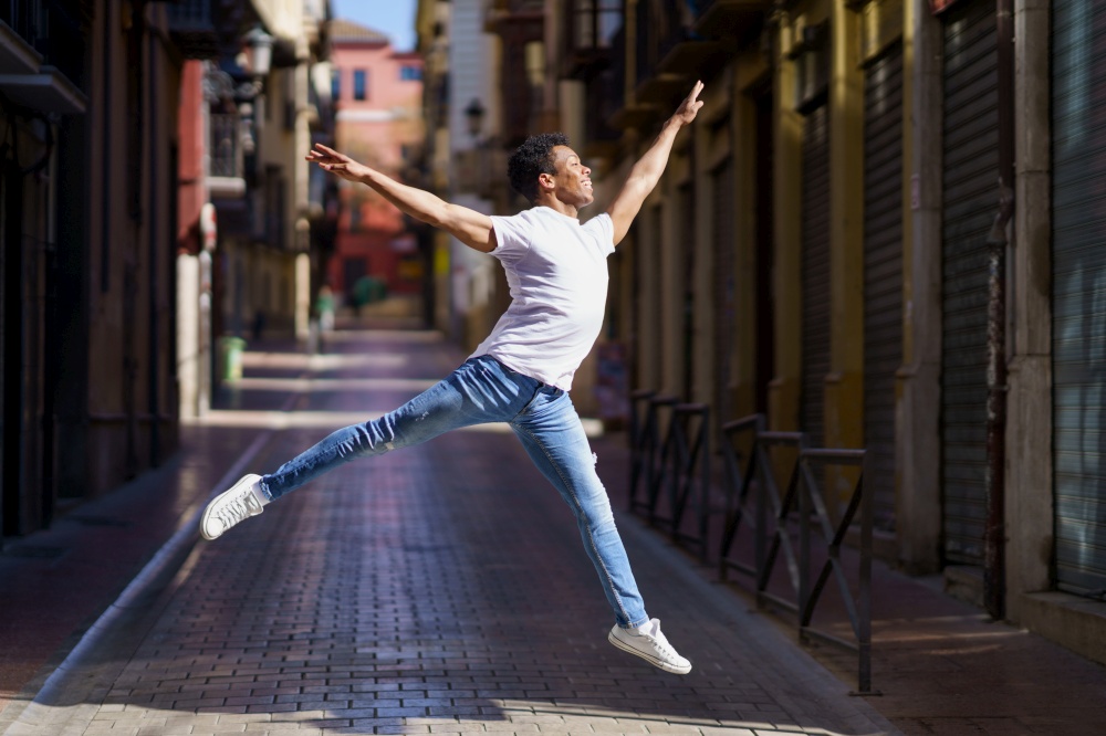 Happy black guy doing an acrobatic jump in the middle of the street. Cuban man.. Happy black guy doing an acrobatic jump in the middle of the street.