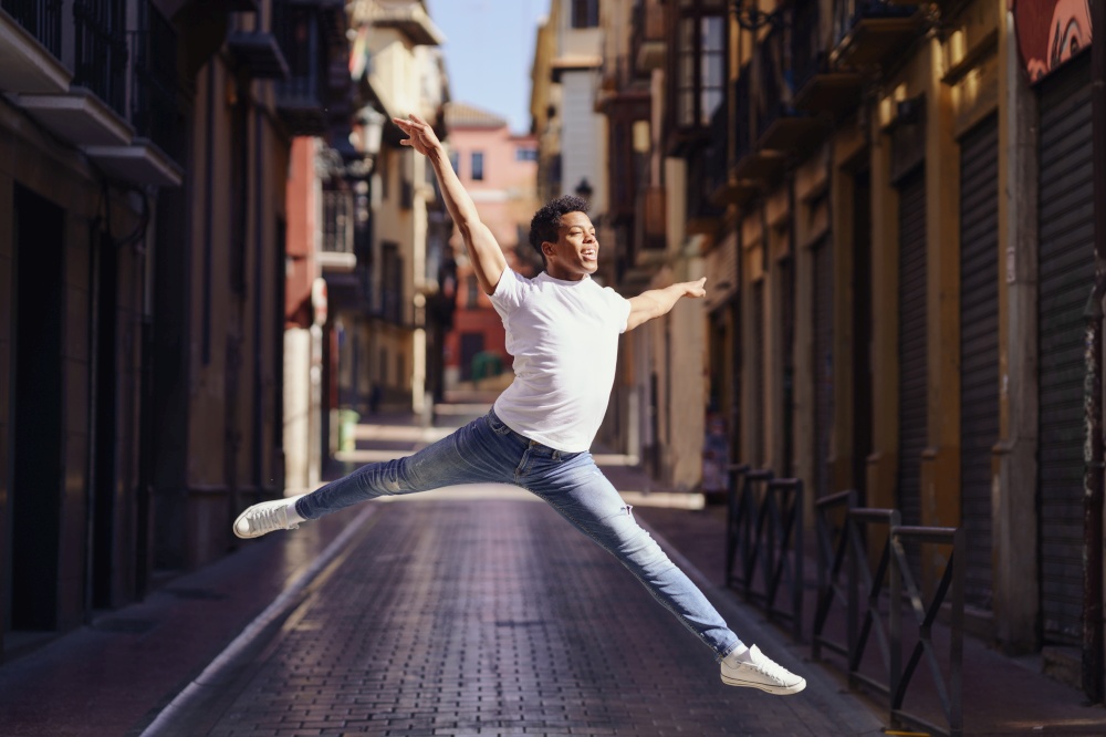 Happy black guy doing an acrobatic jump in the middle of the street. Cuban man.. Happy black guy doing an acrobatic jump in the middle of the street.