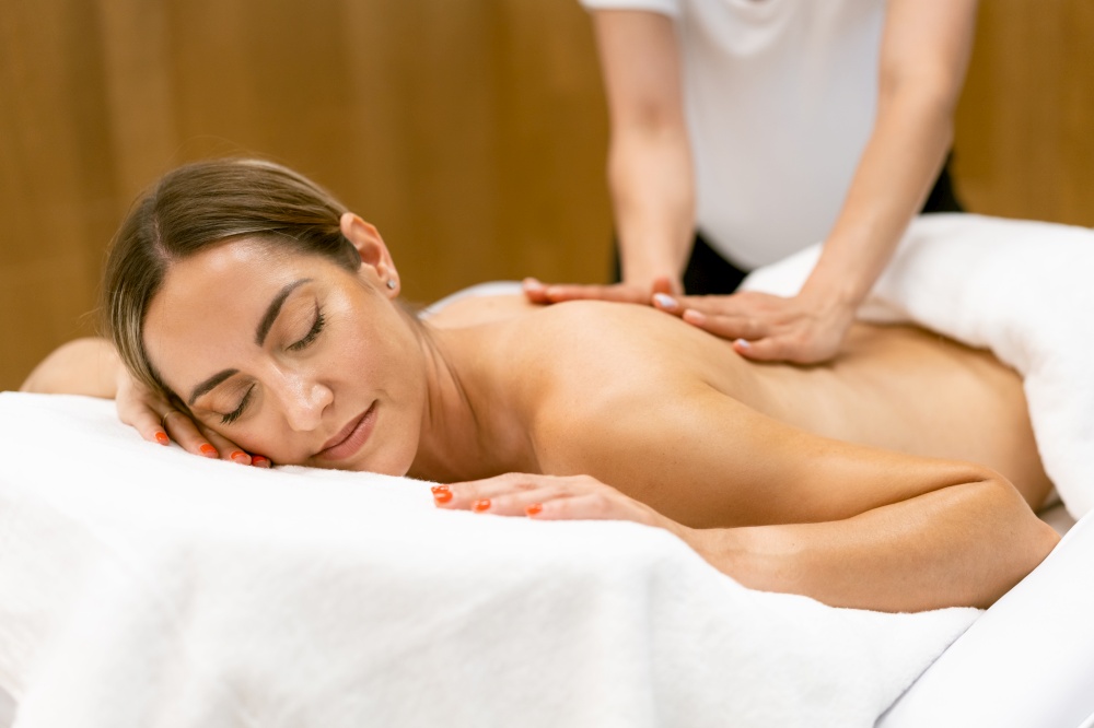 Middle-aged woman having a back massage in a beauty salon. Body care treatment in a beauty centre.. Middle-aged woman having a back massage in a beauty salon.