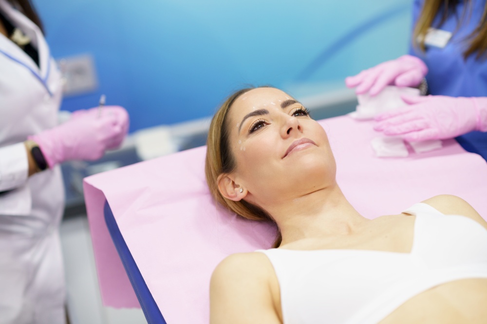 Middle-aged woman lying on the stretcher in an aesthetic clinic waiting for a botulinum toxin treatment.. Middle-aged woman lying on the stretcher in an aesthetic clinic.