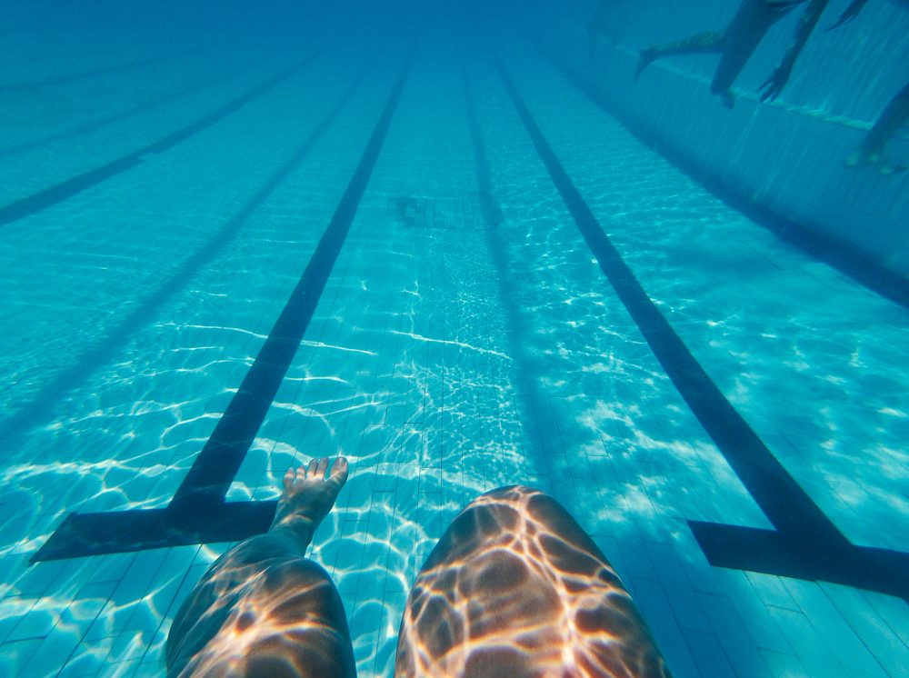 Womans legs underwater in swimming pool. Womans legs underwater in pool