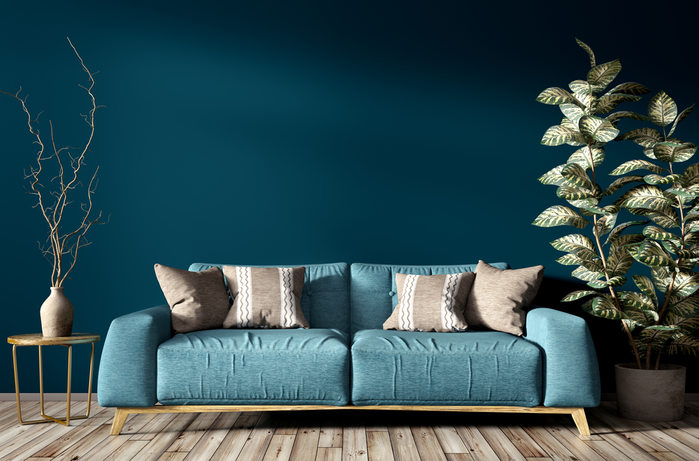 Modern interior of living room with turquoise sofa, home plant and vase with branch against blue wall 3d rendering