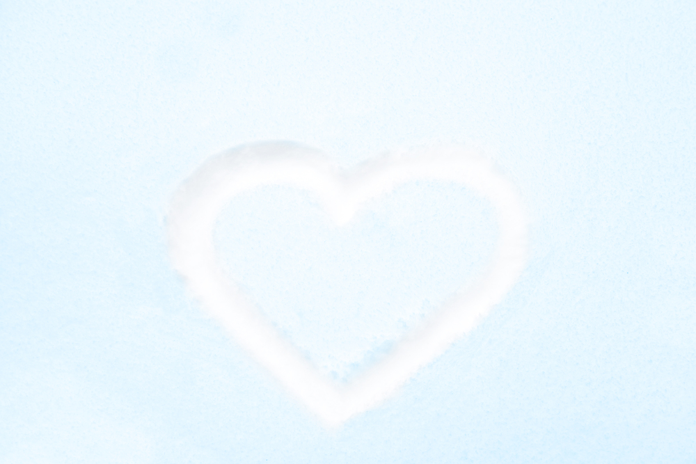 Blue heart shape drawing on white snow as love valentine background