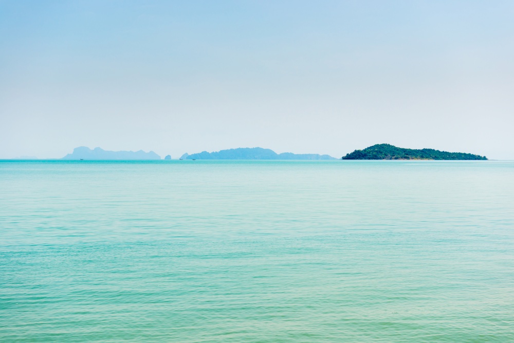 Island in blue sea, calm sea landscape with blue water