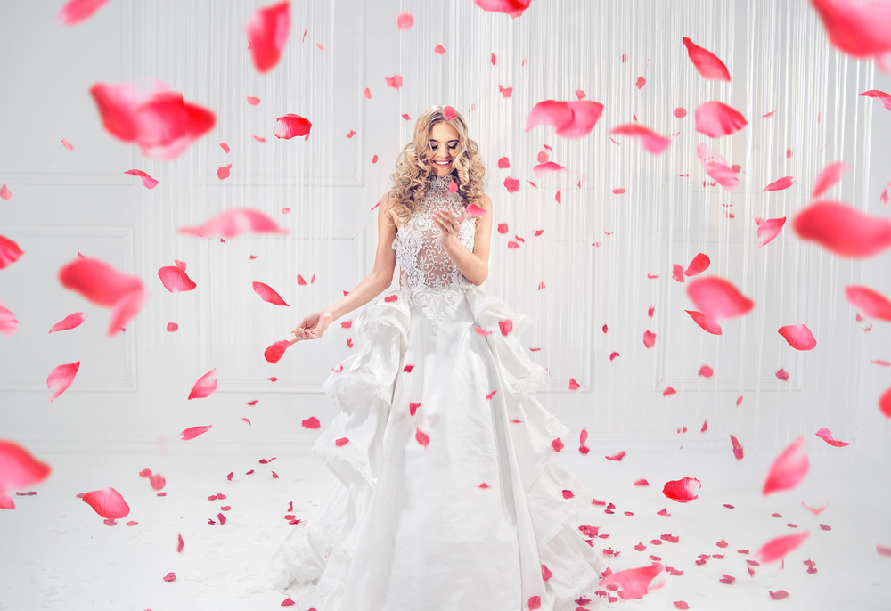 Pretty, elegant blonde dancing among red rose petals