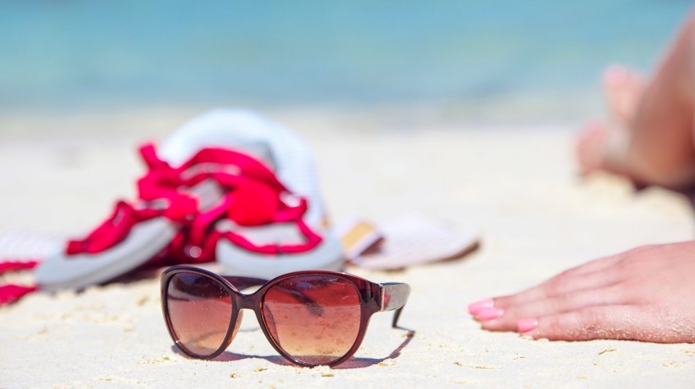 Summer accessories - sunglasses, white beach and tropical view