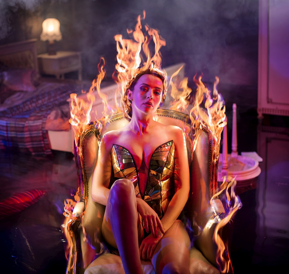 Sensual woman relaxing in the burning, antiwue armchair