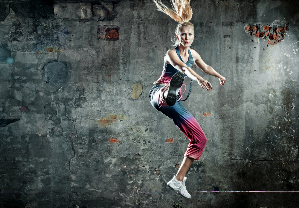 Blonde athlete woman in a jump pose
