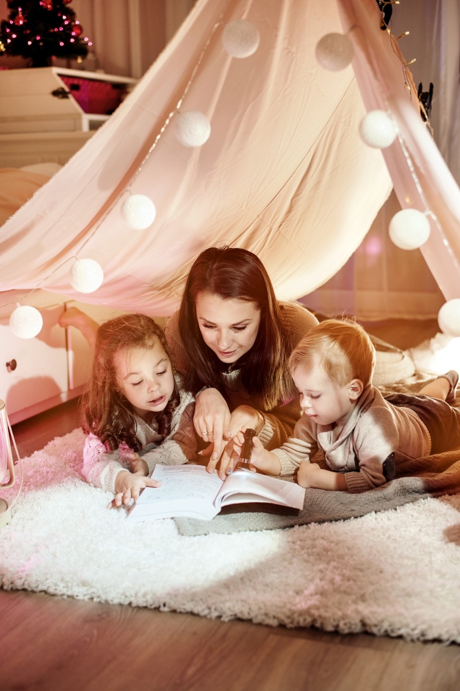 Young mother reading a novel with her children