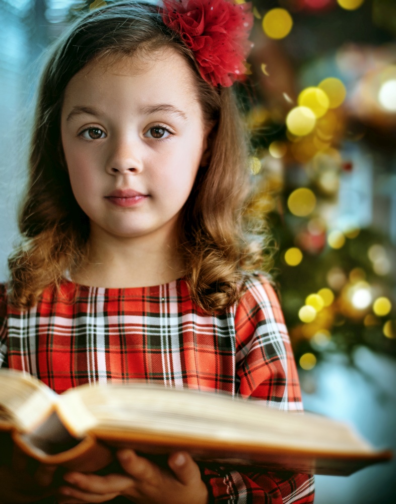 Closeup portrait of a cute and little girl holding a book