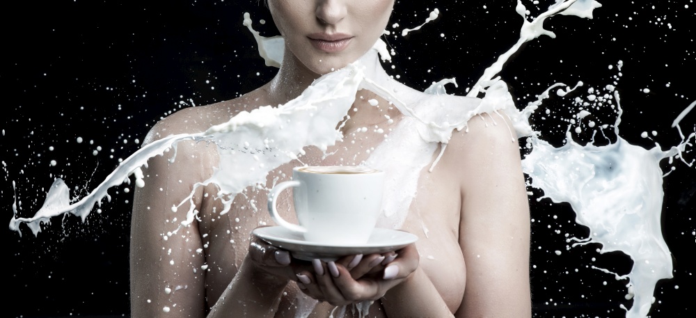 Milk splashing against a nude lady holding a cup of coffee