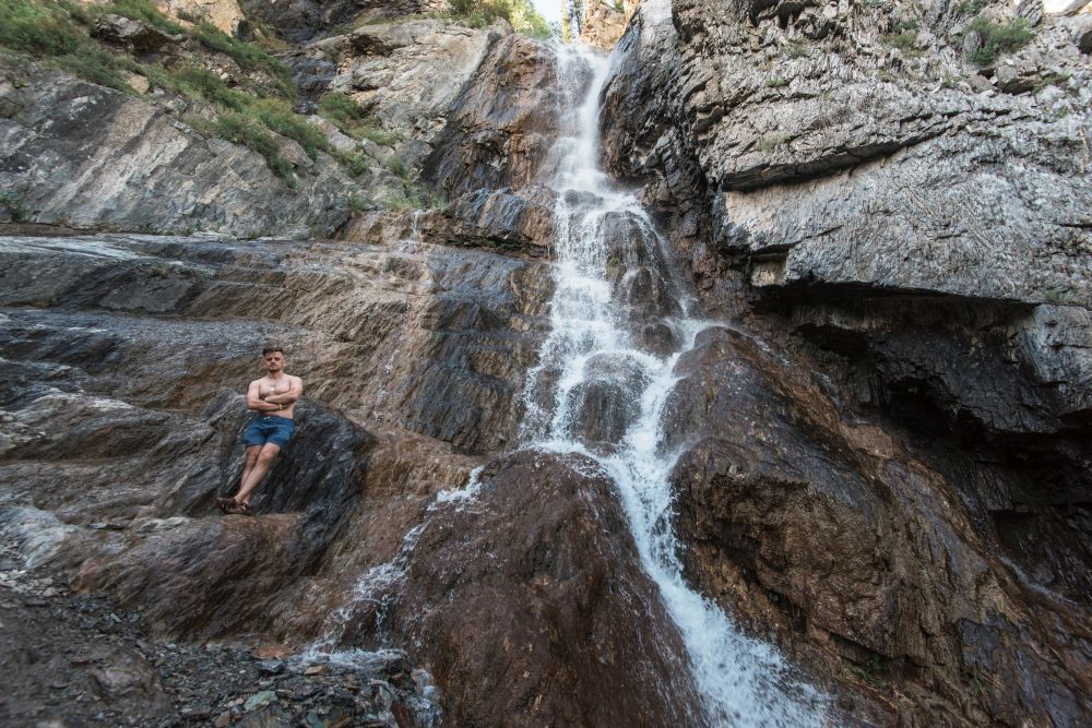Man at waterfall in Altai Mountains territory. Waterfall in Altai Mountains