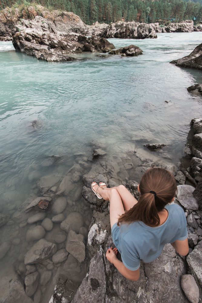 Woman resting at river in Altai Mountains territory. Woman resting at river