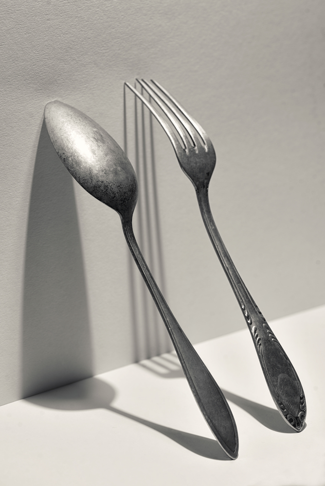 Concept of silver fork and spoon on wall