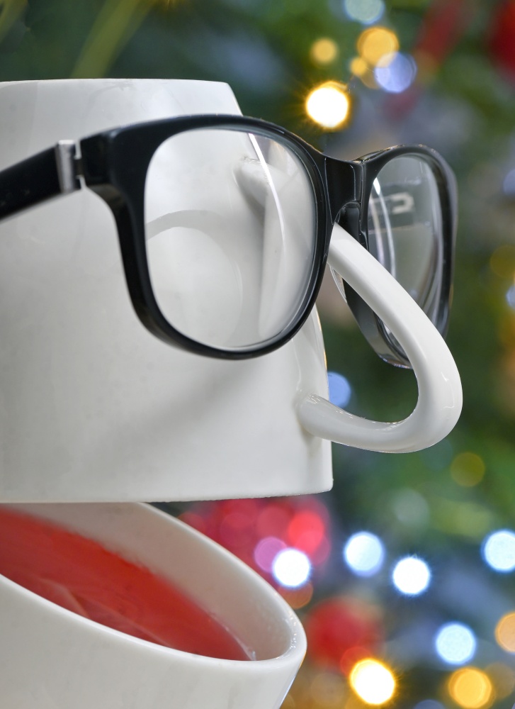 Conceptual Teacup with Eyeglasses Laughing with holidays background