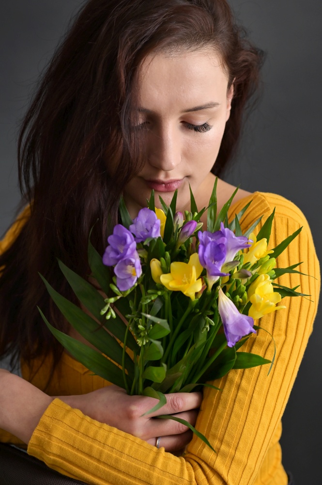 Young Woman and Bouquet Of Freesia Flowers in Studio