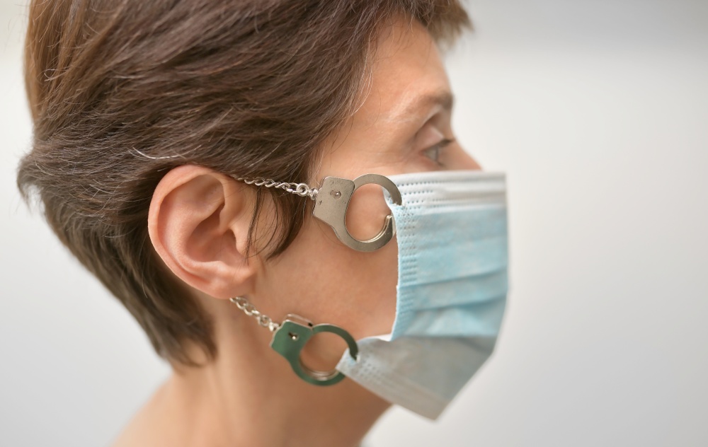 Concept Woman With Medical Mask Locked with Handcuffs