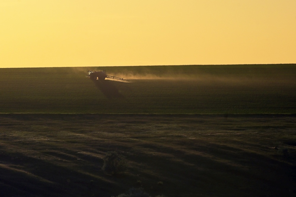 Farming Tractor Plowing And Spraying On Spring Field