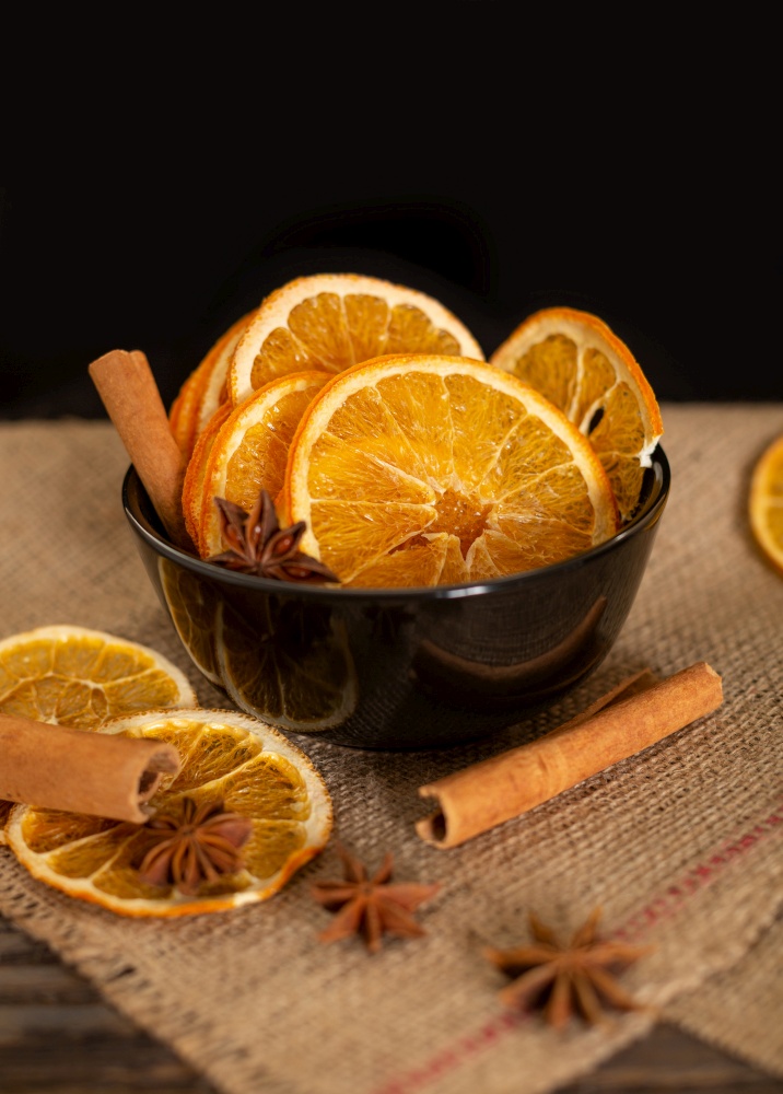 Dried orange slices, cinnamon and star anise on a black background. Spices for mulled wine.