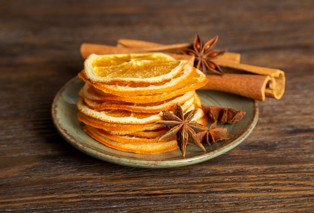 Dried orange slices, cinnamon and star anise on a brown wooden background. Spices for mulled wine.