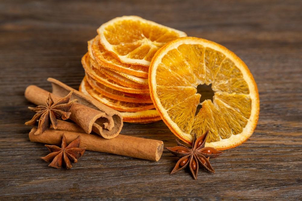 Dried orange slices, cinnamon and star anise on a brown wooden background. Spices for mulled wine and winter decoration.