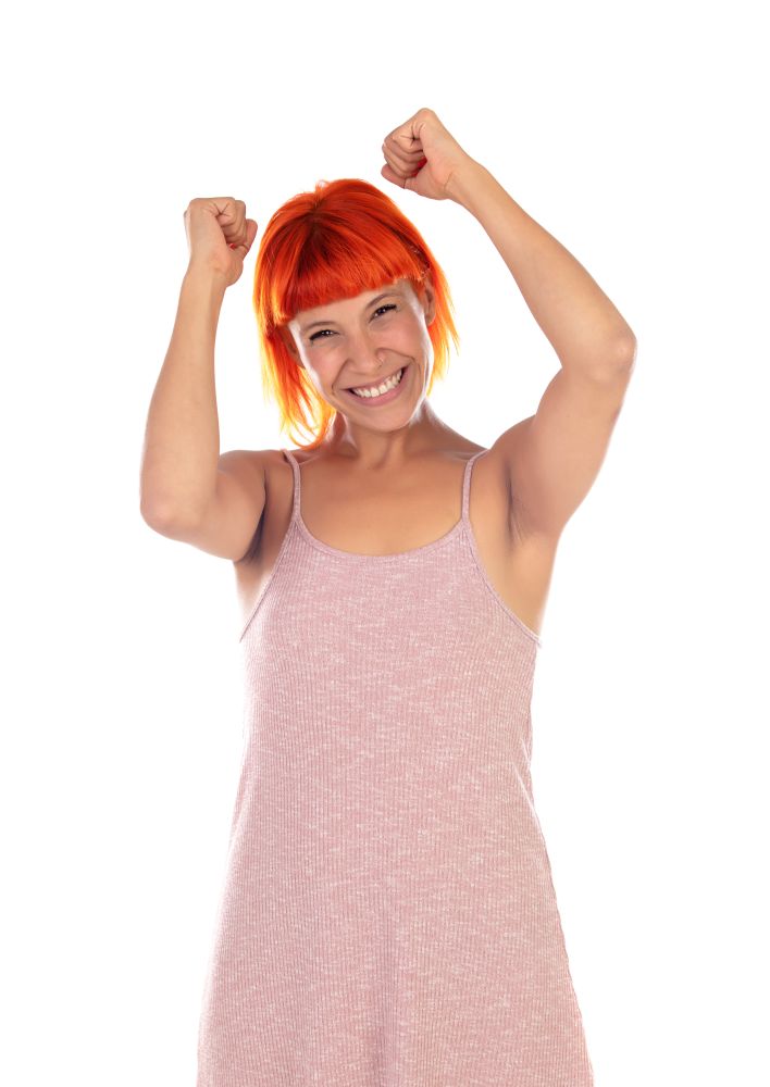 Winner woman with pink dress celebrating something isolated on a white background